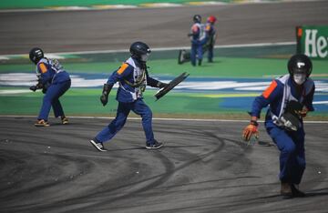 Los operarios del circuito recogen las piezas del asfalto durante el Safety Car. 