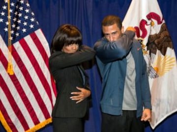 Haciendo su característico gesto de besarse el bíceps en su visita a la Casa Blanca, con Michelle Obama.