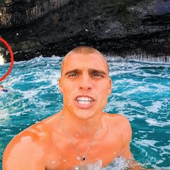 Surfea una ola que pasa por un estrecho agujero en un acantilado