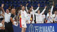 Spain's Juancho Hernangomez and teammates celebrate on the bench.