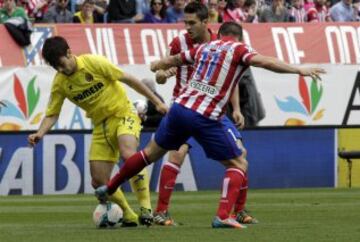 El centrocampista del Villarreal Manu Trigueros (i) disputa un balón con el centrocampista uruguayo del Atlético de Madrid Cristian Rodríguez (d).