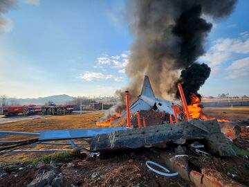 Los bomberos realizan operaciones de extinción del fuego del avión que se salió de la pista en el Aeropuerto Internacional de Muan en Muan, provincia de Jeolla del Sur, Corea del Sur.