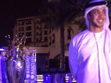 Sheik Mansour Bin Al-Nahyan junto con el trofeo que acredita al Mancherter City campeón de la Premier League.