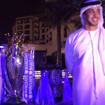 Sheik Mansour Bin Al-Nahyan junto con el trofeo que acredita al Mancherter City campeón de la Premier League.