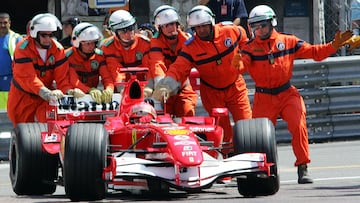 Comisarios de pista de Mónaco empujan el Ferrari de Schumacher tras quedarse parado en la pista durante la clasificación de 2006.