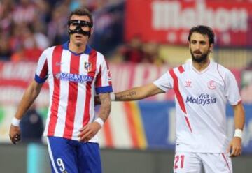 El delantero croata del Atlético Madrid, Mario Mandzukic, con una máscara protectora, vigilado por el defensa del Sevilla, Nico Pareja.
