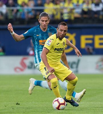 El jugador del Villarreal Cazorla trata de controlar el balón ante el defensa rojiblanco Filipe Luis. 

