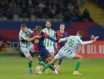 El delantero espa?ol del Barcelona, ??Lamine Yamal, lucha por el baln con el defensa francs del Real Betis, Romain Perraud, y el mediocampista espa?ol del Real Betis, Sergi Altimira.