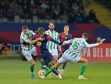 El delantero español del Barcelona, ​​Lamine Yamal, lucha por el balón con el defensa francés del Real Betis, Romain Perraud, y el mediocampista español del Real Betis, Sergi Altimira.