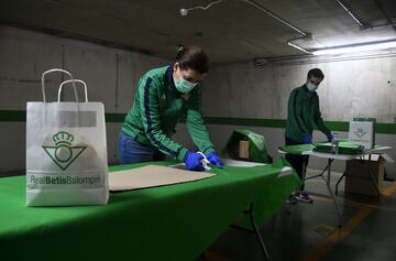 Los voluntarios trabajan en el aparcamiento del estadio Benito Villamarín preparando el material que luego distribuyen a los más necesitados, como es el caso del hogar de ancianos de Santa Justa. 
