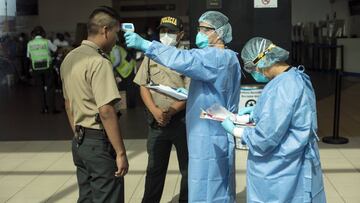 A doctor measures the temperature of a police officer as a precaution against the spread of the new coronavirus, at a semi-closed airport, in Lima, Peru, Tuesday, March 17, 2020. Peru's President Martin Vizcarra has declared a state of emergency, ordering citizens to stay in their homes and temporarily suspending certain constitutional rights, to contain the spread of coronavirus. The vast majority of people recover from the new virus. (AP Photo/Rodrigo Abd)