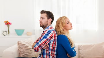 Angry young couple sitting back to back at home