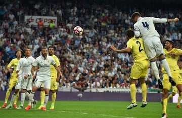 Real Madrid's defender Sergio Ramos (R) heads the ball to score a goal during the Spanish league football match Real Madrid CF vs Villarreal CF at the Santiago Bernabeu stadium in Madrid on September 21, 2016. / AFP PHOTO / GERARD JULIEN