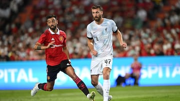 Manchester United's Portuguese midfielder Bruno Fernandes (L) and Liverpool's English defender Nathaniel Phillips