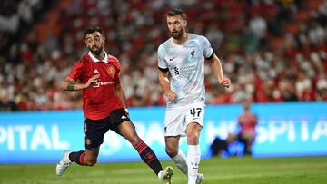 Manchester United's Portuguese midfielder Bruno Fernandes (L) and Liverpool's English defender Nathaniel Phillips