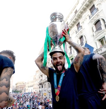 Insigne haciendo una mueca a la cámara mientras sostiene la copa sobre su cabeza.