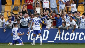 Vigaray, autor del gol, y Kagawa celebran con la afición del Zaragoza el tercer gol en Alcorcón.