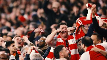 Aficionados del Arsenal realizan el gesto de "llorar" a los seguidores del Real Madrid presentes en el estadio.
