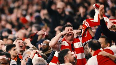 Aficionados del Arsenal realizan el gesto de "llorar" a los seguidores del Real Madrid presentes en el estadio.