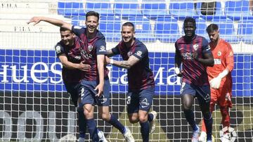 Jugadores del Huesca celebran un gol ante la tristeza de Caro.