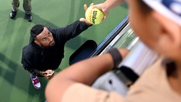 El tenista australiano Nick Kyrgios firma una pelota a un aficionado tras anunciar su retirada en el cuadro individual del Open de Atlanta.