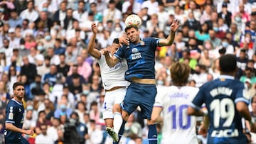 Real Madrid's Dominican forward Mariano Diaz (L) and Espanyol's Uruguayan defender Leandro Cabrera jump for the ball during the Spanish League football match between Real Madrid CF and RCD Espanyol at the Santiago Bernabeu stadium in Madrid on A
