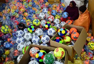 Los balones de fútbol, que se fabrican para la exportación y el mercado indio, son confeccionados por pequeños contratistas en Jalandhar, India. Los dueños de las fábricas distribuyen las materias primas entre los trabajadores de los barrios más marginales de la ciudad que cosen los balones en sus casas.