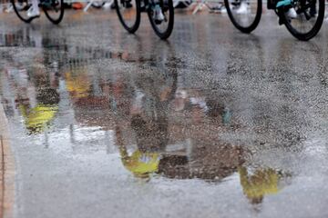 Varios corredores se ven reflejados en los charcos de agua de la calzada en la octava etapa entre las localidades de Dénia y Xorret de Catí.