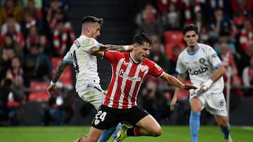 Girona's Spanish midfielder #14 Aleix Garcia fights for the ball with Athletic Bilbao's Spanish midfielder #24 Benat Prados during the Spanish league football match between Athletic Club Bilbao and Girona FC at the San Mames stadium in Bilbao on February 19, 2024. (Photo by ANDER GILLENEA / AFP)