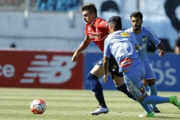 El jugador de Universidad Católica, Nicolas Castillo, centro, disputa el balón con Raul Osorio de O'Higgins.