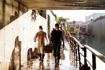 La gente camina tras las inundaciones provocadas por las fuertes lluvias en Massanassa, Valencia.