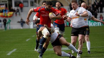 El jugador de la selección española de rugby, Sebastien Rouet (i), protege el balón ante un jugador de la selección de Alemania, durante el partido correspondiente al penúltimo partido clasificatorio para el campeonato mundial disputado hoy en la Ciudad Universitaria de Madrid.