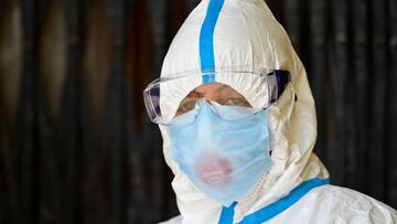 A doctor wearing a protective gear waits for patients to collect swab samples at a COVID-19 coronavirus testing centre during a government-imposed nationwide lockdown as a preventive measure against the COVID-19 coronavirus, in Srinagar on May 9, 2020. (Photo by Tauseef MUSTAFA / AFP)
