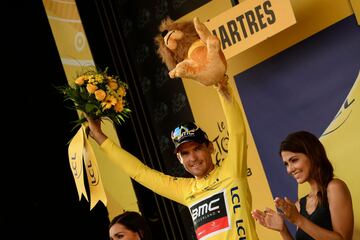 El ciclista del equipo BMC Racing Team, Greg Van Avermaet celebra en el podio, luciendo la camiseta amarilla de líder.