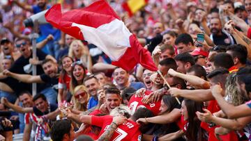 Los jugadores del Atlético celebran el gol de Carrasco con los aficionados.