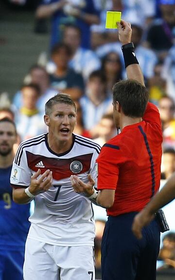 El ¨¢rbitro Nicola Rizzoli muestra cartulina amarilla a Bastian Schweinsteiger.
