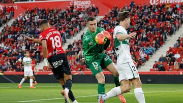 PALMA DE MALLORCA, 13/12/2025.- El guardameta del Elche Iñaki Peña (c) atrapa un balón durante el encuentro correspondiente a la jornada 16 de LaLiga EA Sports entre el RCD Mallorca y el Elche disputado este sábado en Son Moix. EFE/ Cati Cladera