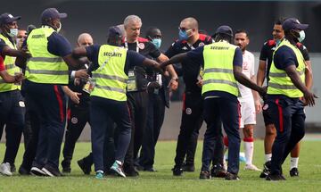 Los miembros de seguridad desalojan el terreno de juego.