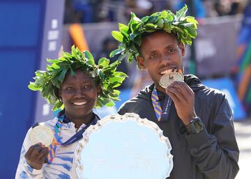 La ganadora de la prueba femenina Mary Keitany de Kenia y el ganador de la prueba masculina Lelisa Desisa de Etiopía posan con la medalla tras ganar la Maratón de Nueva York.