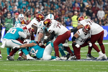 Los Dolphins defienden una jugada de ataque de los Commanders.