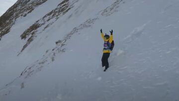 El freerider aranés, equipado con una chaqueta amarilla, casco y máscara, levanta los brazos tras su caída en Eagle Cliff, Fieberbrunn (Austria), durante la prueba del Freeride World Tour celebrada allí el 14 de marzo del 2022.