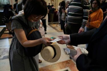 Los fieles reciben imágenes del papa Francisco mientras rinden homenaje al difunto pontífice en la Basílica de San Pedro del Vaticano, donde su cuerpo permanecerá en capilla ardiente durante tres días.