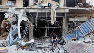 A man sits amongst the rubbles at the site of an Israeli strike, amid the ongoing conflict between Israel and Palestinian Islamist group Hamas, in Khan Younis in the southern Gaza Strip, October 19, 2023. REUTERS/Mohammed Salem