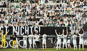 Jugadores del Borussia M?nchengladbach celebran frente a los cartones colocados en la grada con las im¨¢genes de sus aficionados.