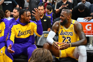 Bronny James talks with his father, LeBron James, on the Lakers bench.