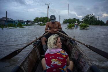 Varias personas recorren una calle inundada en una embarcación tras el paso del huracán Helene en Guanimar, provincia de Artemisa, Cuba.

