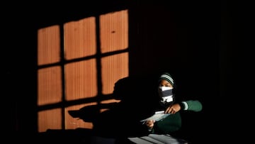 A Grade 7 student of the Sitoromo Junior Secondary School in Sterkspruit, prepares her work on a desk on July 06, 2020. - The school reopened today for their Grade 7 pupils only, after being shut for two weeks due to a case of COVID-19 coronavirus among i