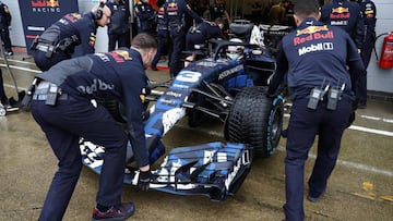 Los mecánicos de Red Bull empujan el coche de Ricciardo a boxes durante el filming day que hizo en Silverstone.