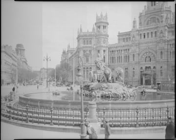 La gente camina alrededor de la Fuente de Cibeles.