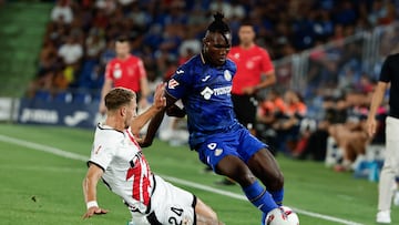 GETAFE (C.A. DE MADRID), 24/08/2024.- El delantero nigeriano del Getafe Christantus Uche (d) con el balón ante el defensa francés del Rayo Florian Lejeune (i), durante el partido de la segunda jornada de Liga disputado este sábado entre el Getafe y el Rayo Vallecano en el estadio Coliseum. EFE/Sergio Pérez
